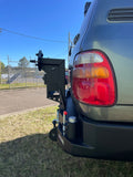 100 Series Rear Bar with LED Taillights, black powder-coated finish, right-side wheel carrier, and customisable aluminium accessories including Jerry can holders and gear storage box for off-road vehicles.