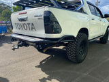 N80 Hilux Tub Chop Rear Bar with high clearance and recovery points, powder-coated finish, robust front wing supports, concealed mudflap mounts, and optional number plate lights and bracket.